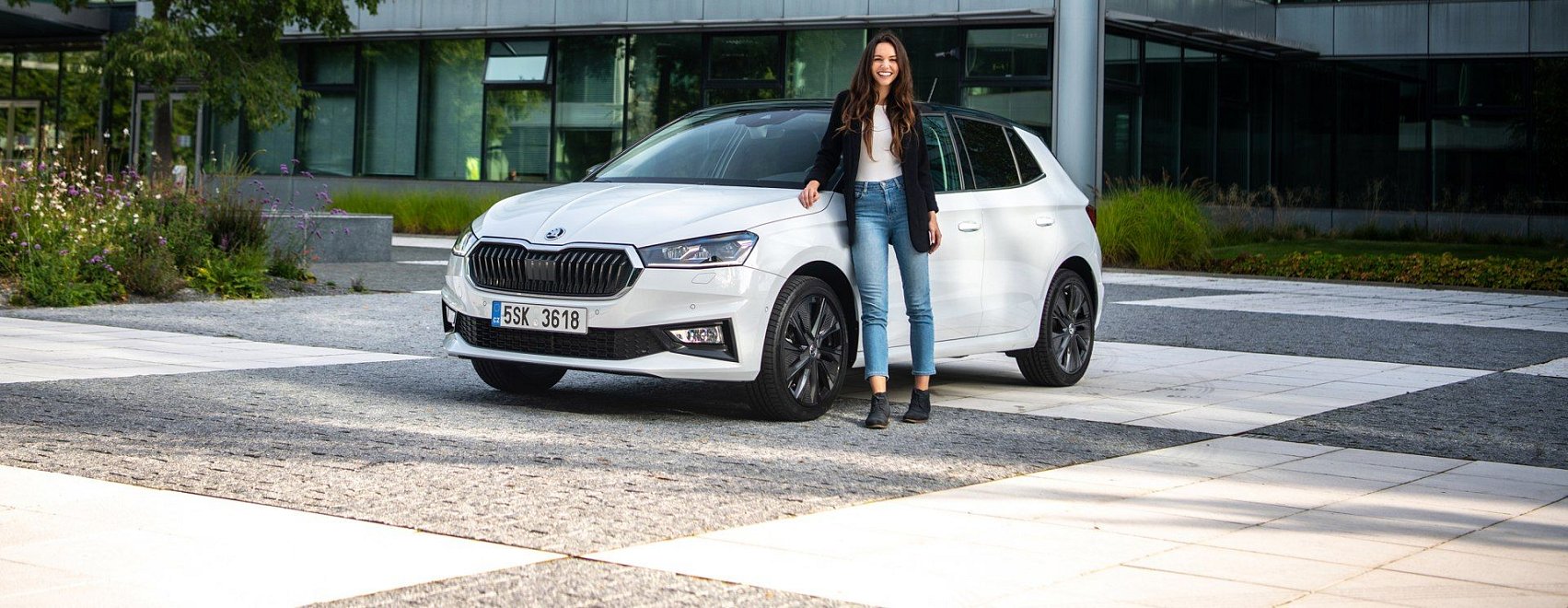 Rodina nastupuje do kompaktního hatchbacku před pobočkou Auto ESA