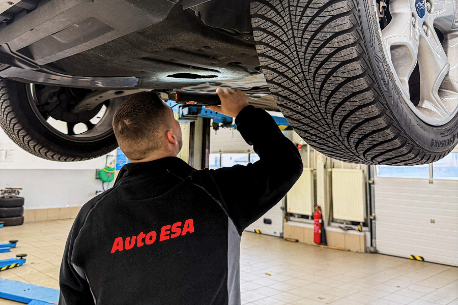Technická práce v automotive – mladý pracovník při kontrole vozidla v moderním servisu Auto ESA