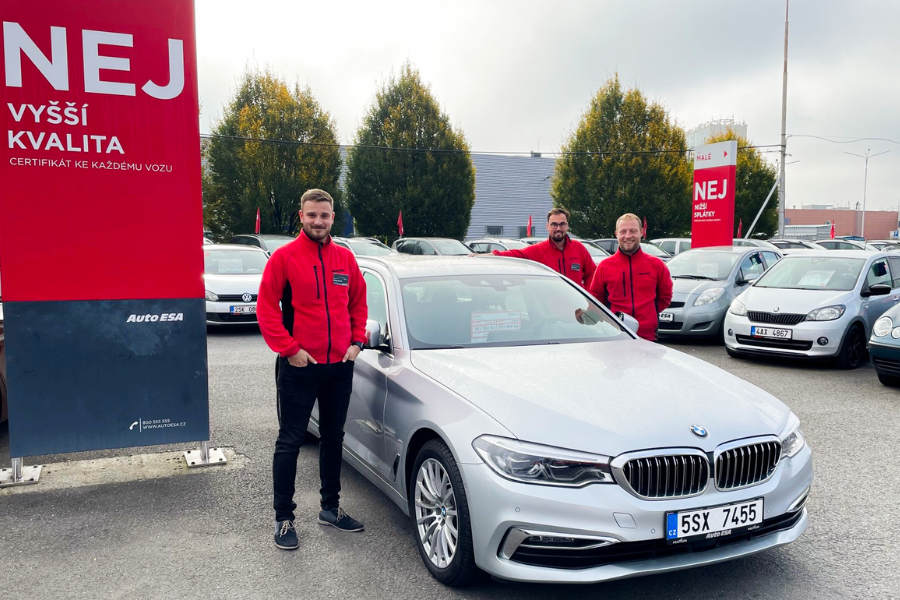 Tým prodejců Auto ESA před vozidlem na prodejní ploše pobočky - práce v automotive.